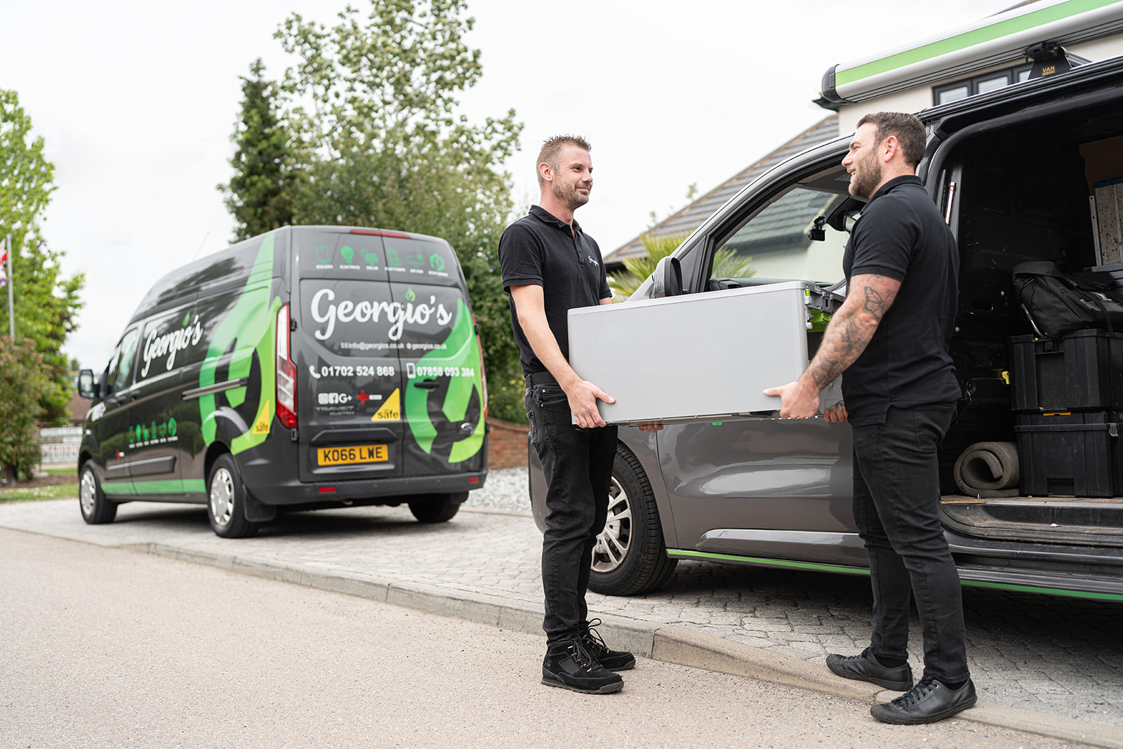 Two Georgio's engineers unloading equipment from a branded van on a residential street in Essex